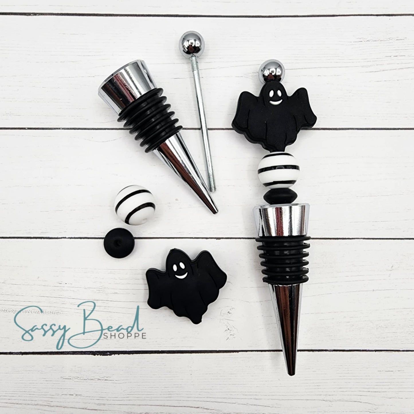 Close-up of Halloween-themed silicone beads in ghost designs for DIY wine stopper making