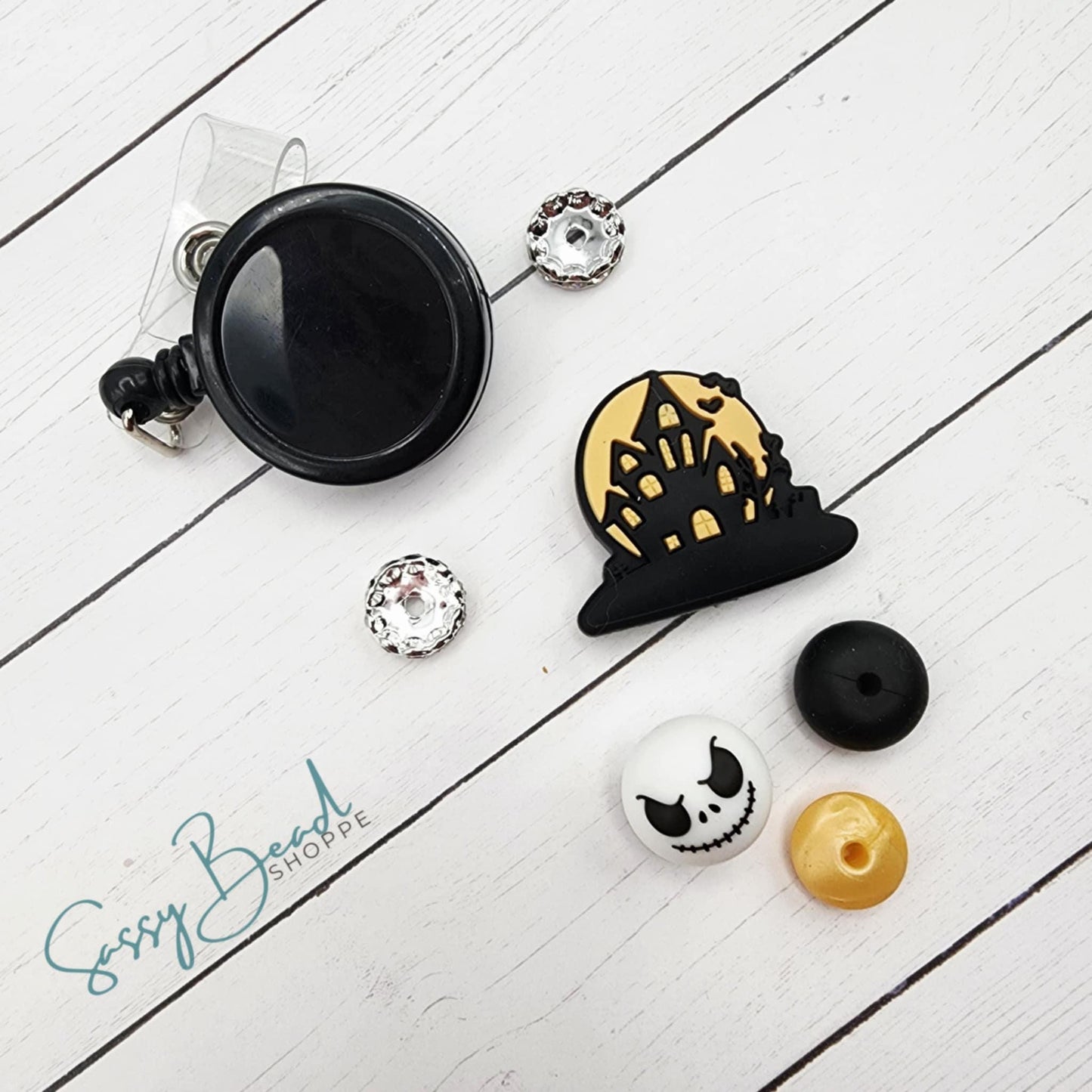 Fright DIY kit styled flat lay showing beads for badge reel, including seasonal haunted house and skeleton designs