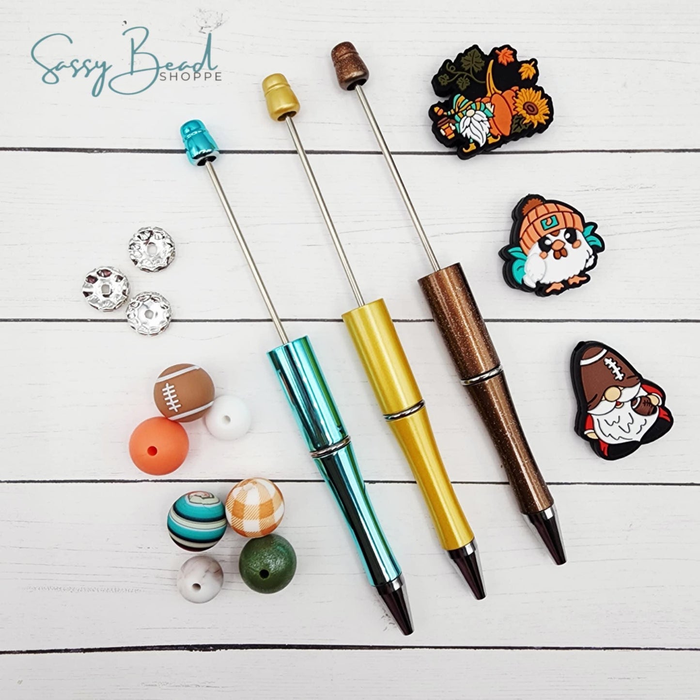Close-up of Thanksgiving-themed silicone beads and turkey, gnome, and football focal beads to design for DIY pen making