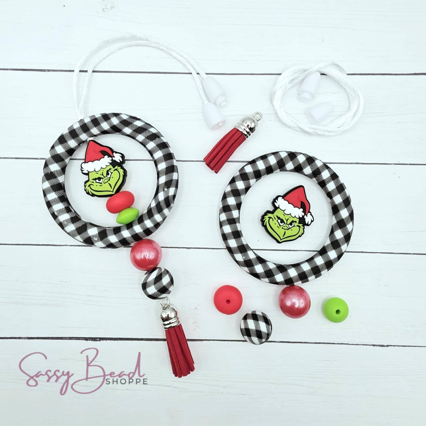 Close-up of Christmas-themed silicone beads with plaid ring, green guy focal beads and Holiday designs for DIY car charm making