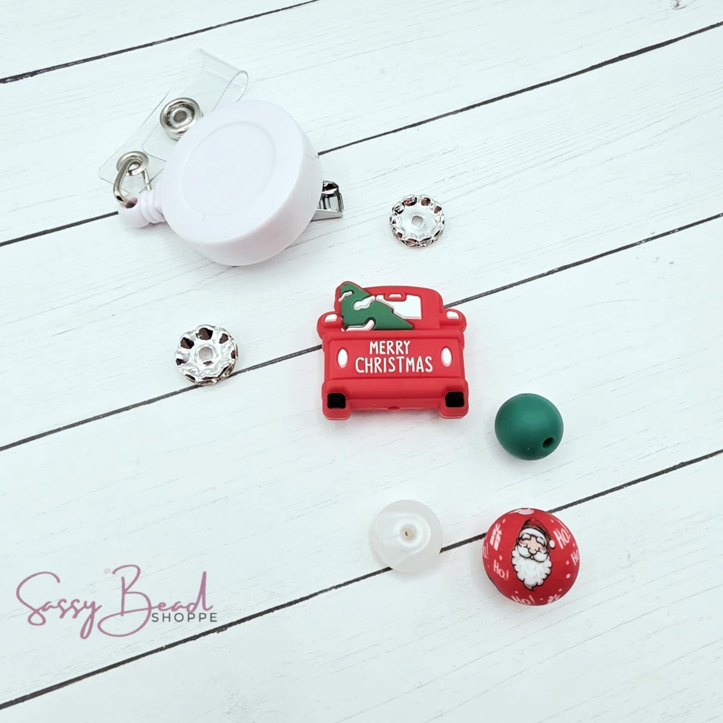 Haulin' Holiday Cheer DIY kit styled flat lay showing beads for badge reel, including seasonal Christmas truck and holiday designs