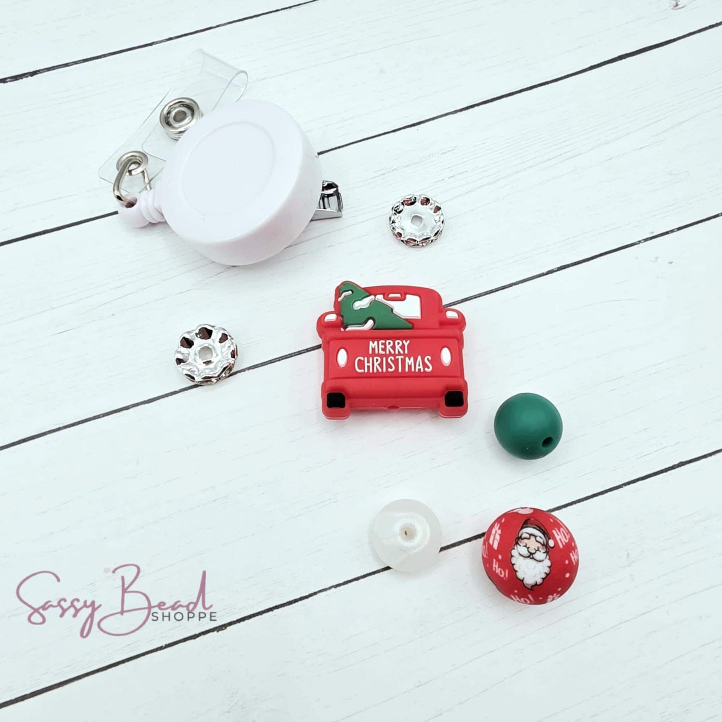Haulin' Holiday Cheer DIY kit styled flat lay showing beads for badge reel, including seasonal Christmas truck and holiday designs