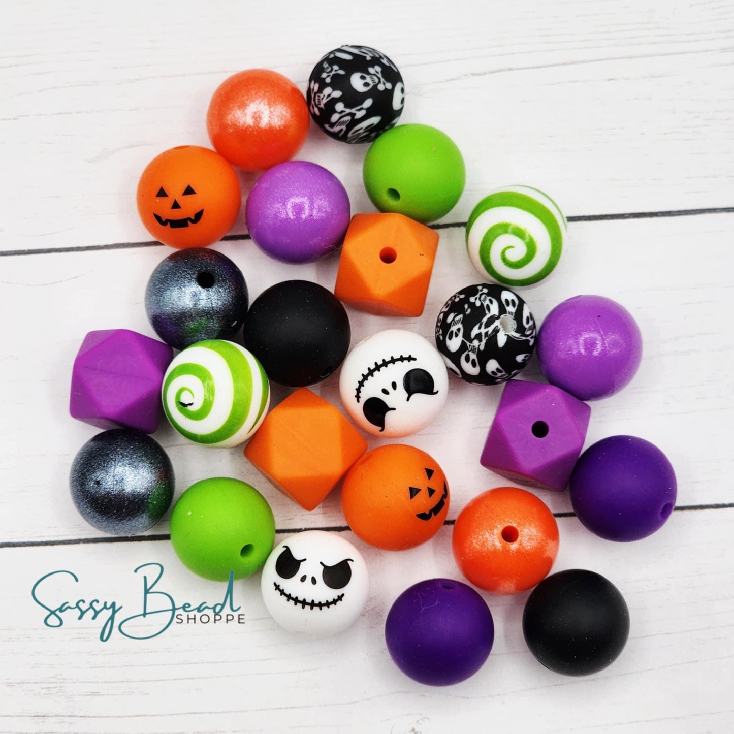 Spooky Season Silicone bead mix styled flat lay showing beads for beaded pens, including seasonal pumpkin, skull, swirl designs