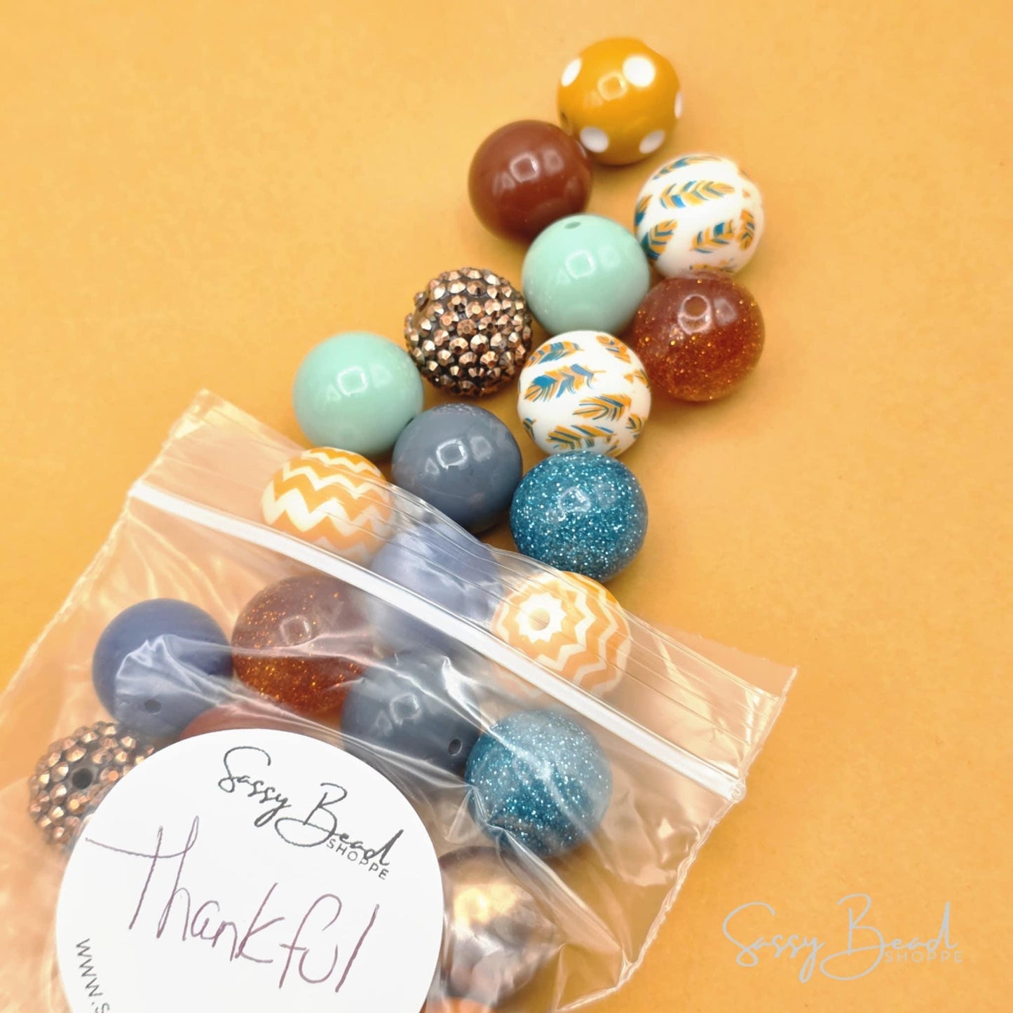 Thankful bead mix styled flat lay showing beads for beaded pens, including feathers, polka dots, chevron, shimmer & rhinestone designs