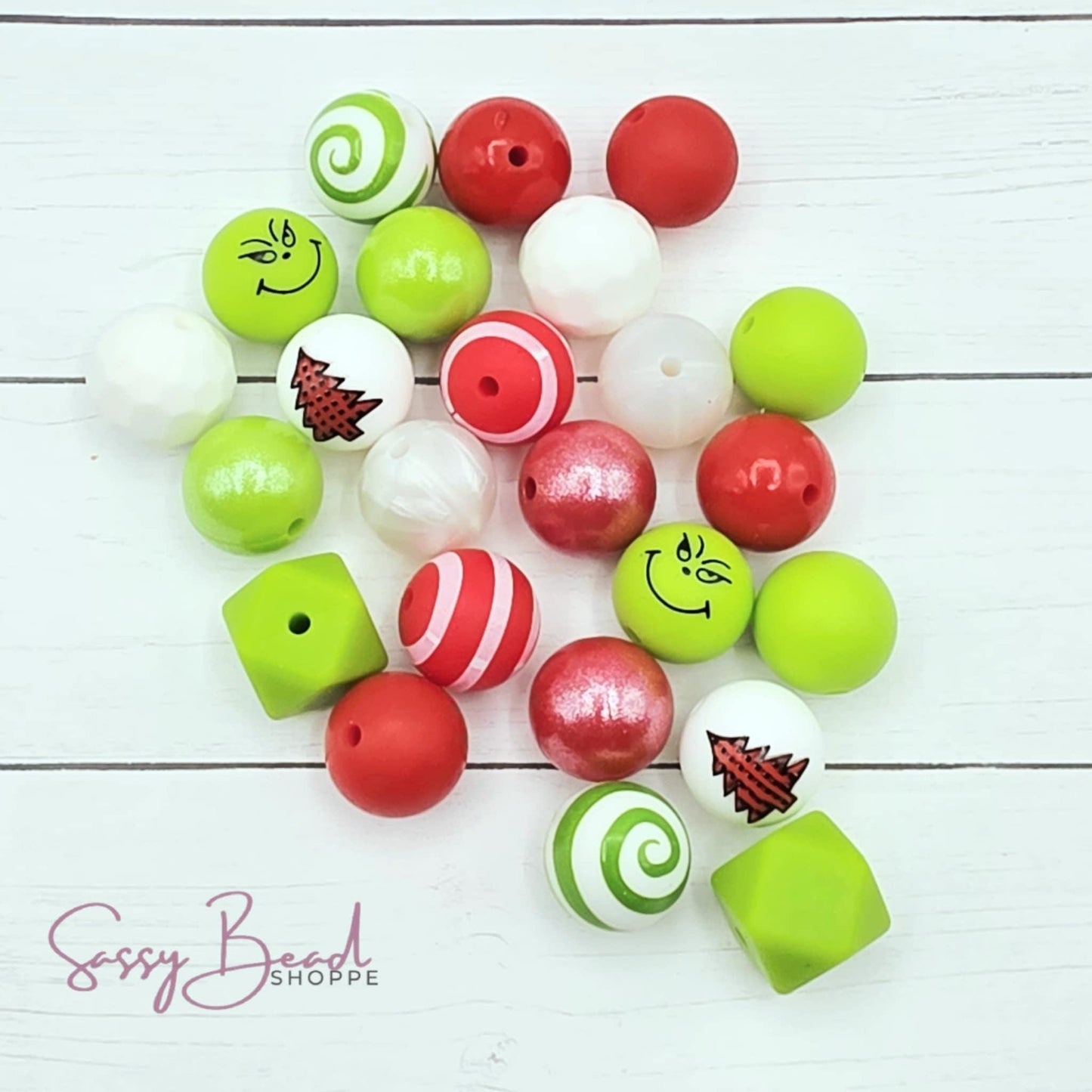 Close-up of Christmas-themed silicone beads in lime green, red & white designs for DIY pens, badge reels, wristlets, cookie scribes, and all your jewelry making