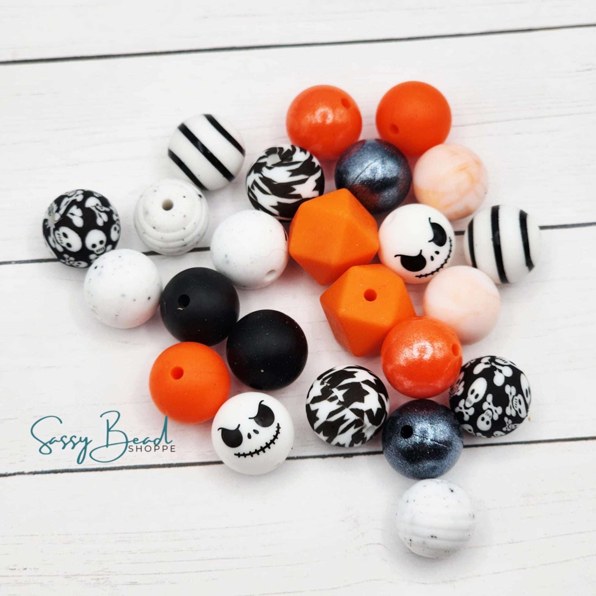 Close-up of Halloween-themed silicone beads in sugar skulls and crossbones designs for DIY pens, badge reels, wristlets, cookie scribes, and all your jewelry making
