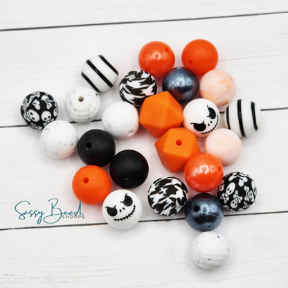 Close-up of Halloween-themed silicone beads in sugar skulls and crossbones designs for DIY pens, badge reels, wristlets, cookie scribes, and all your jewelry making