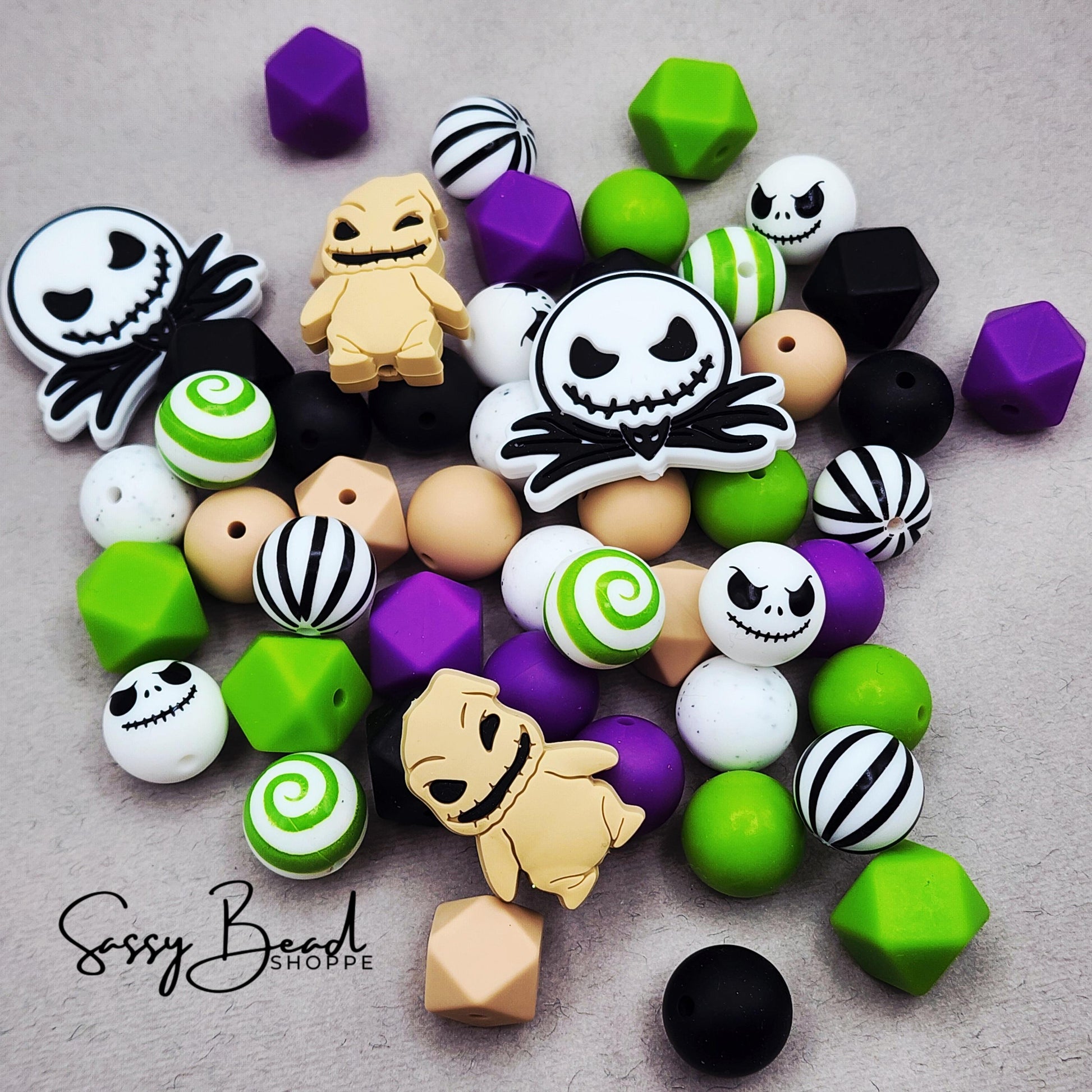 Close-up of Halloween-themed silicone beads in stripe and swirl designs with Jack, Creepy Cute Bug Monster focal beads for DIY pens, badge reels, wristlets, cookie scribes, and all your jewelry making