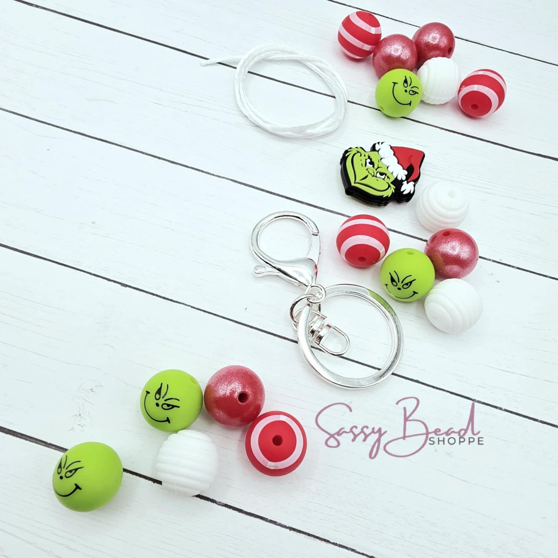 Mean Green Holiday wristlet styled flat lay showing beads for beaded wristlets, including seasonal mean guy, stripe designs