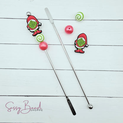 Close-up of Christmas-themed silicone beads with a  Santa, red & green bead designs for DIY stir stick making