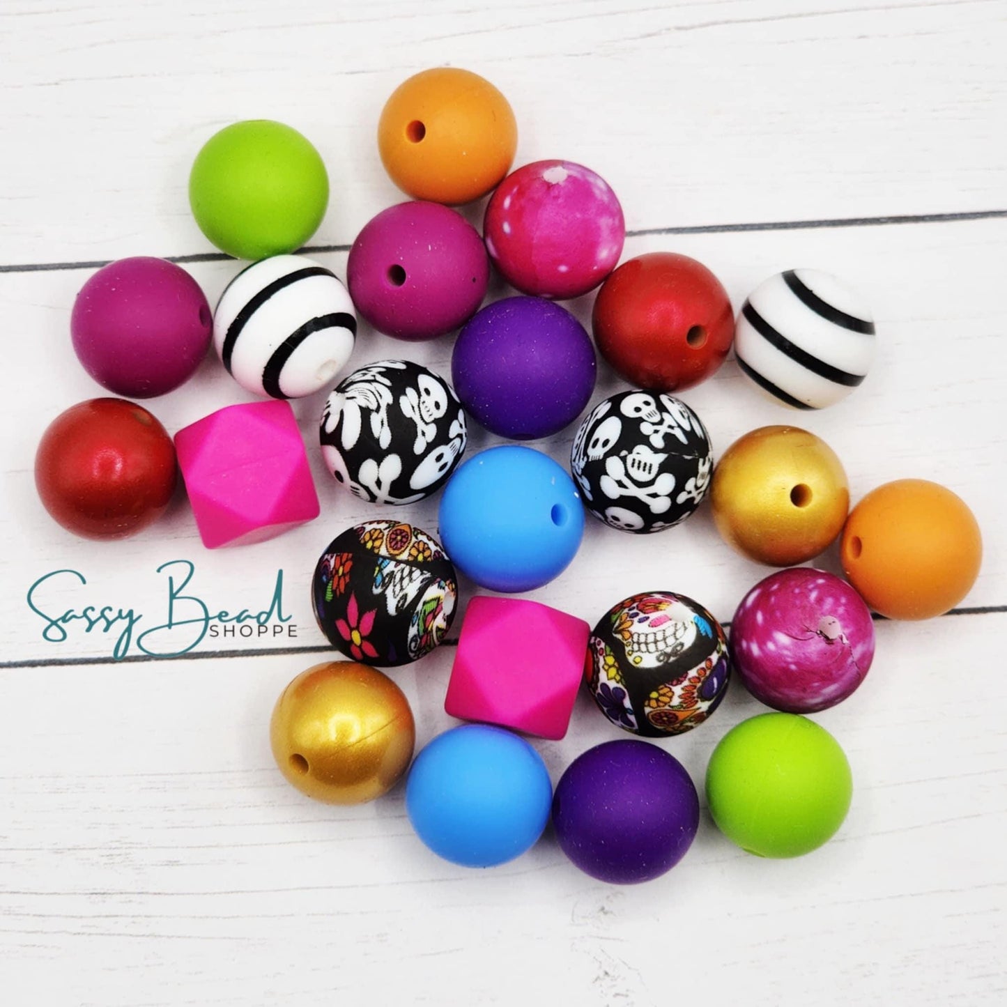Close-up of Halloween-themed silicone beads in sugar skulls and crossbones designs for DIY beaded pens, badge reels, wristlets, cookie scribes, and all your jewelry making