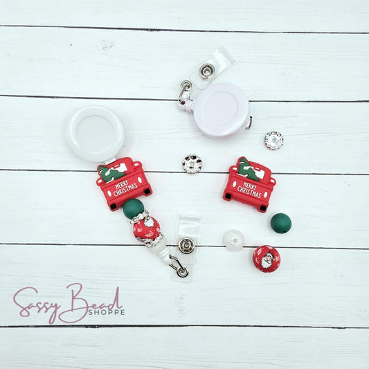 Close-up of Christmas-themed silicone beads in Christmas truck with tree in the back designs for DIY badge reel making